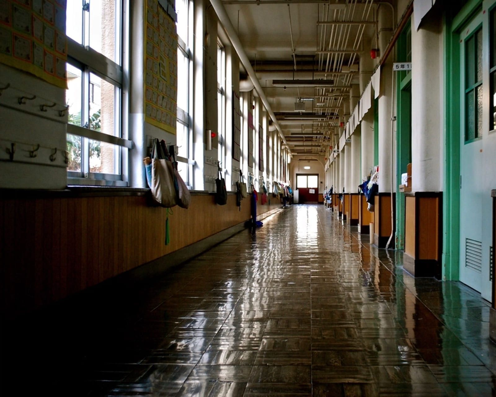 A long empty corridor with a row of windows down one side
